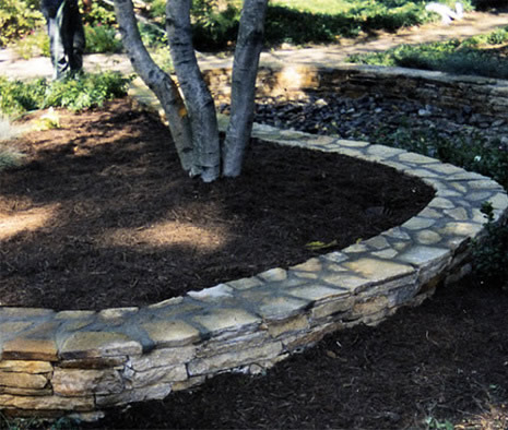 Stone wall surrounding landscaped area
