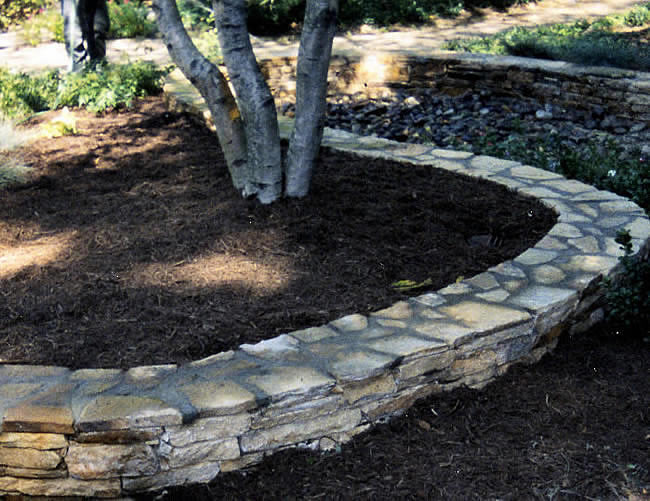 Stone wall around mulch garden